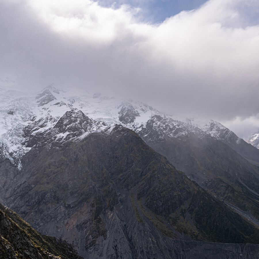 A pale mountain range disappearing into low cloud